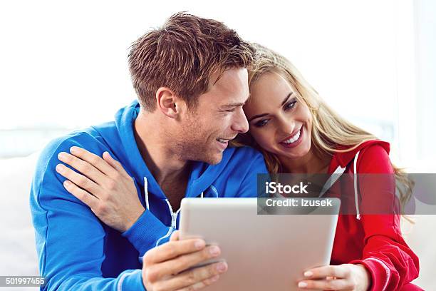 Young Couple Using A Digital Tablet Stock Photo - Download Image Now - 20-24 Years, Adult, Adults Only