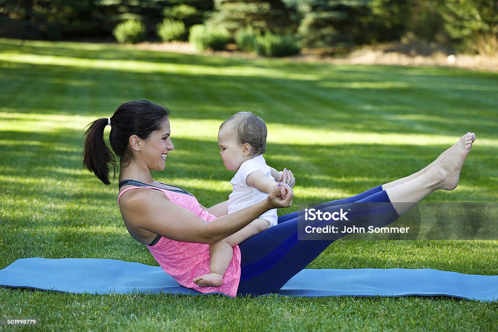 Mommy and Son fitness time A woman exercising with her baby on a yoga mat outdoors  Yoga Stock Photo