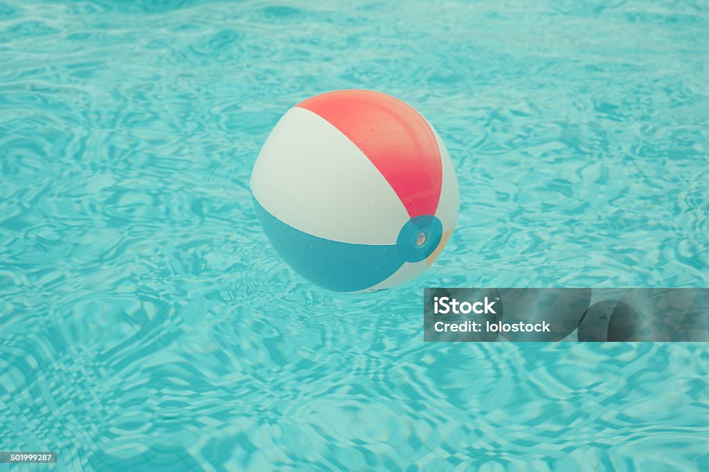 Beach ball floating in swimming pool A beach ball is floating in a swimming pool Beach Stock Photo