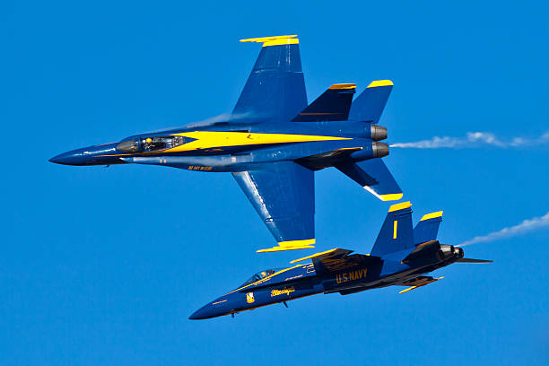 US Navy Blue Angels performing air show routine Pensacola, USA - November 11, 2011: US Navy Blue Angels performing air show routine on November 11, 2011 during the Blue Angels Homecoming Air Show at NAS Pensacola in Pensacola, FL. Blue Angels fly F-18 Hornets with special livery representing colors of US Navy: Yellow and Navy Blue. US Navy Blue Angels is the oldest active military aerobatic demonstration squadron and is considered the best Demonstration Squadron in the world. supersonic airplane editorial airplane air vehicle stock pictures, royalty-free photos & images