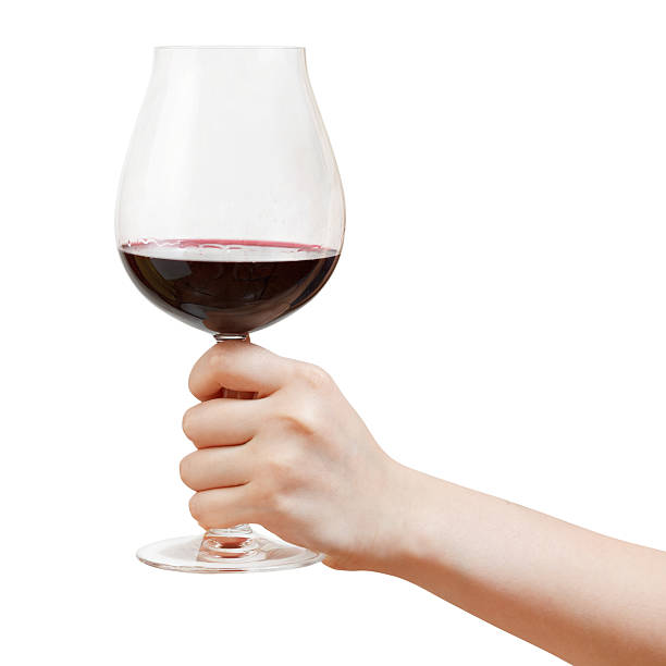 istock hand holds goblet glass with red wine 502001419