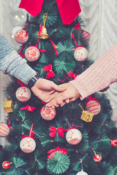 istock Couple holding hands in front of a Christmas tree 502002758