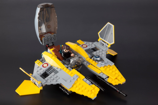 Tambov, Russian Federation - June 21, 2014: LEGO Star Wars Jedi Interceptor set with opening cockpit, folding wing flaps, dual shooters, Anakin and R2-D2 on black background. Item 75038. Studio shot.