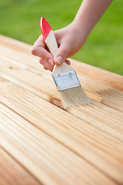 istock Hand with brush on a wooden background 502002865