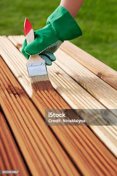 Applying Protective Varnish On A Patio Wooden Floor Stock Photo - Download Image Now