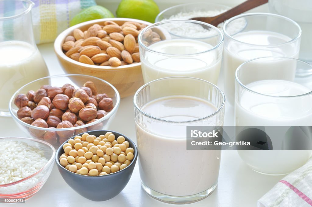 Different vegan milks. Different vegan milks on a table. Hazelnut, rice, soya and almond milk. Substitute for dairy milk. Milk Stock Photo