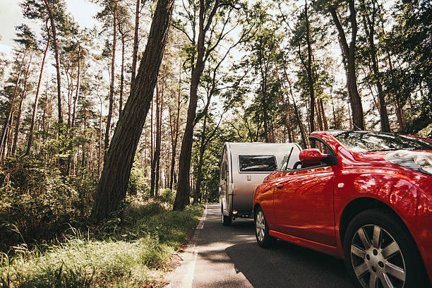 Car and caravan driving on forrest road in germany