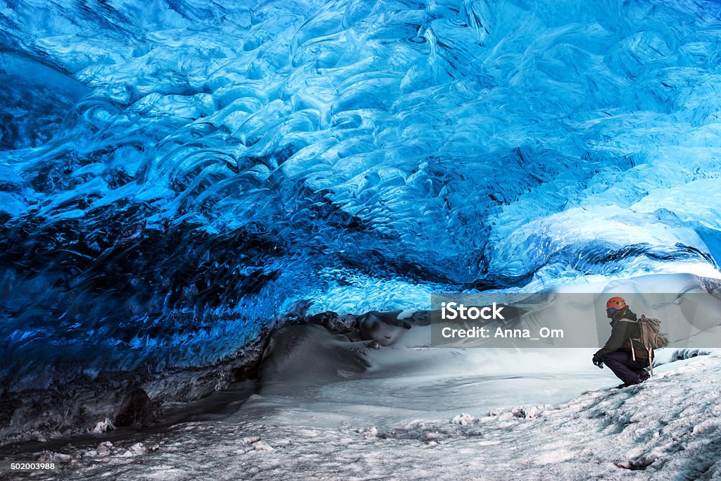 Glacier ice cave of Iceland Man traveler enjoying exotic landmark, sitting in the ice cave, Skaftafell glacier, Vatnajokull National park, amazing nature of Iceland Iceland Stock Photo