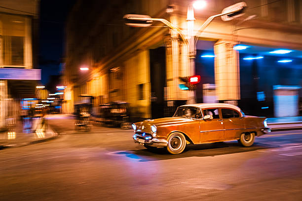 Old American car driving at a street of old Havana, Cuba