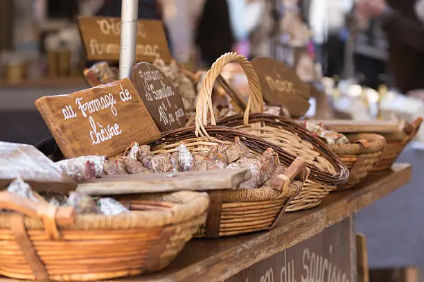 Baskets of Jambon de Somglier (Boar) for sale on a market stall in the town of Sarlat in the Dordogne region of France