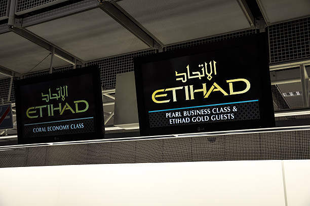 Etihad Check-in screen - Munich Airport, Germany Munich, Germany - July 11, 2014: Etihad Airways Check-in screen for Economy, Business class and First Class at Munich Airport Terminal 1. Abu Dhabi based Etihad Airways serves Munich twice a day. munich airport stock pictures, royalty-free photos & images