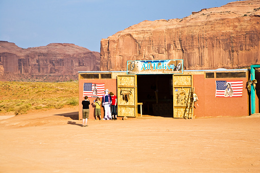 Monument Valley, USA - July 12, 2008:  family is posing  with a picture of John Wayne at John Fords place in monument valley, USA.