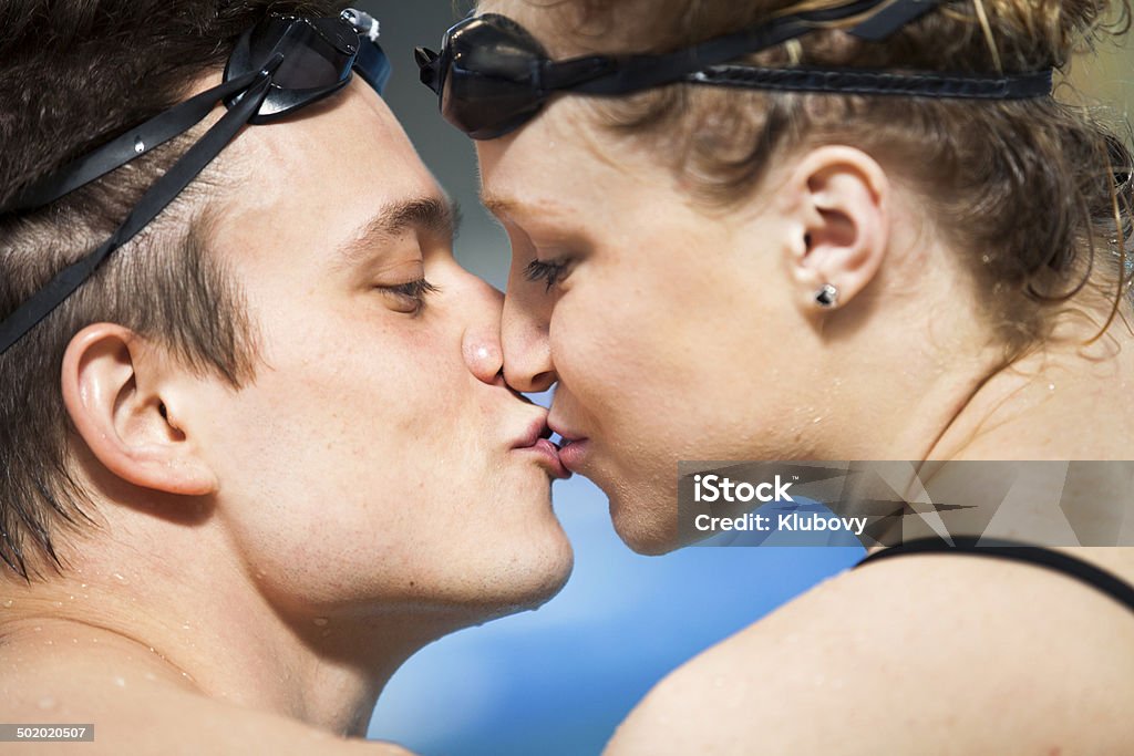 Swimmers in love Two swimmers in love, kissing at a swimming pool. 18-19 Years Stock Photo