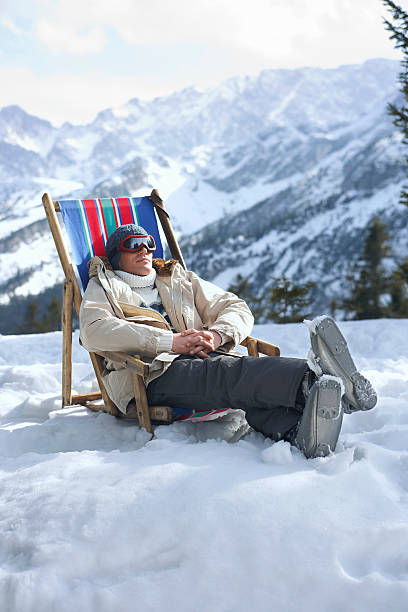 istock Man Sitting On Deckchair In Snowy Mountains 502023825
