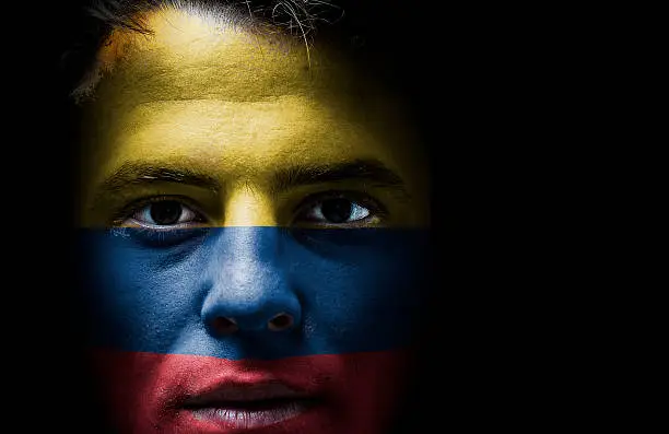 Colombia, Colombian flag on face, isolated on black background. Nationalist and nationalism concept