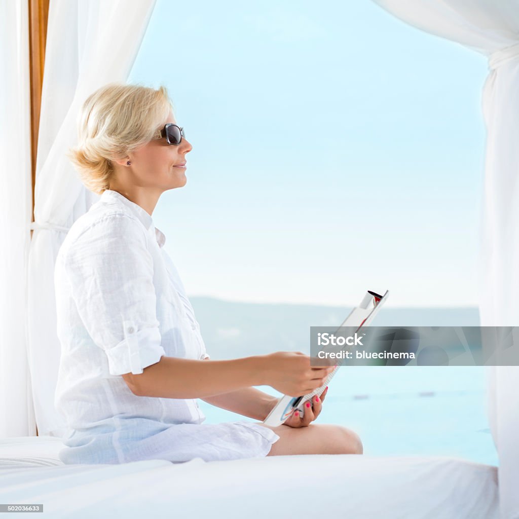 Mujer leyendo una revista en la playa - Foto de stock de Leer libre de derechos