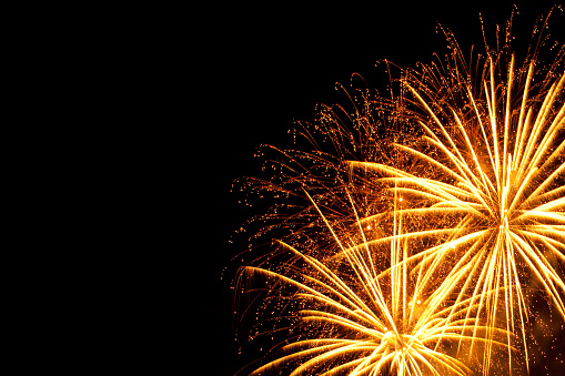 Big orange yellow  fireworks on New Year's Eve on black night  background. Copy space.
