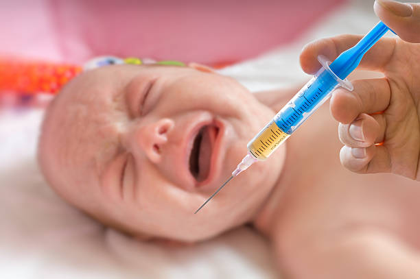 istock Vaccination concept - syringe and crying baby 502037790