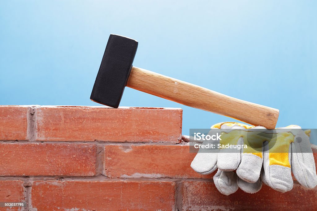 Getting Ready for Demolition Sledgehammer and protective gloves on top of a brick wall Brick Wall Stock Photo