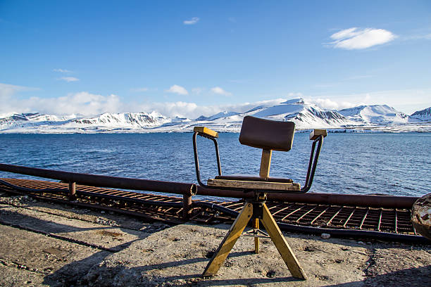 old office chair at the pier of barentsburg 7 spitzbergen/svalbard with mountain background
