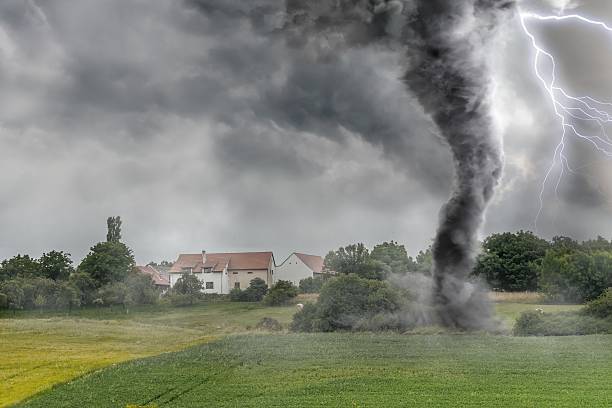 Black tornado funnel and lightning over field during thunderstor