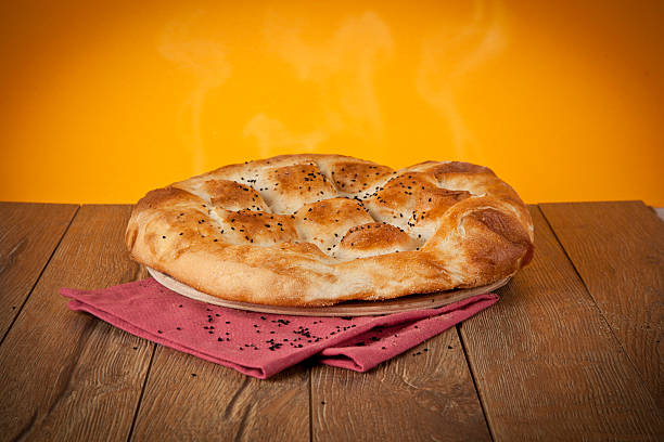 türkische ramadan brot, ramazan pidesi holztisch mit gelbem hintergrund - pita stock-fotos und bilder