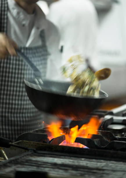 Cooking flatbreads in a Russian stove. Firewood is burning in the firebox. Large pans with flatbreads.