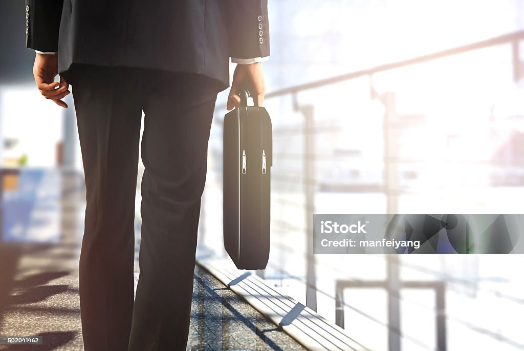 I viaggiatori d'affari a piedi in aeroporto con bagaglio - Foto stock royalty-free di Partire