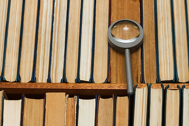istock Magnifying glass on a shelf with books 502041524