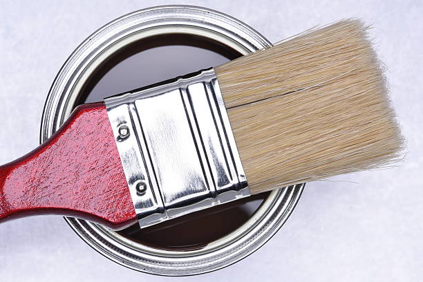 istock Brown paint can with red brush on grey metal background 502041970