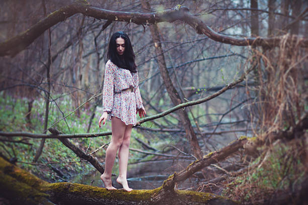 istock Beautiful woman walking on log in forest. 502042454