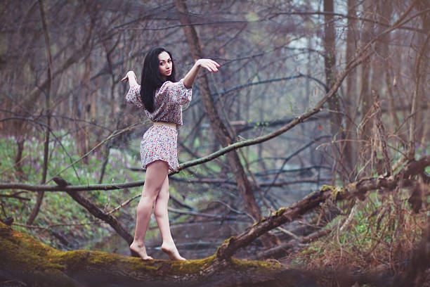 istock Beautiful woman walking on log in forest. 502042584