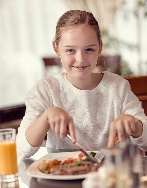 istock Young girl eating in a restaurant 502043986