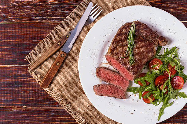 istock Ribeye steak with arugula and tomatoes. 502045916