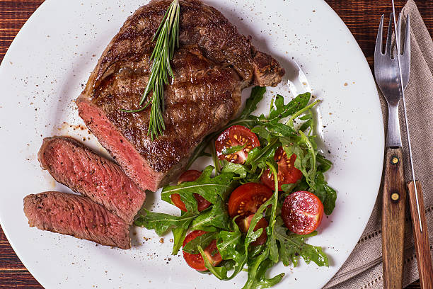 istock Ribeye steak with arugula and tomatoes. 502046034
