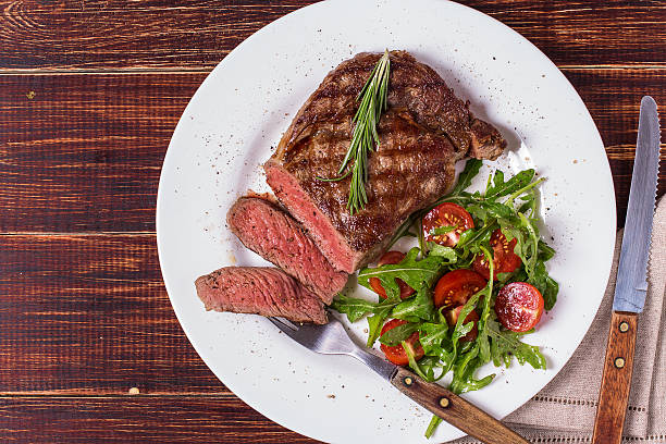 istock Ribeye steak with arugula and tomatoes. 502046128