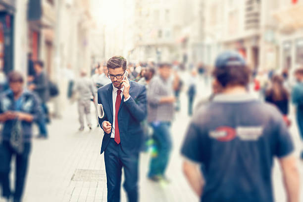 Young businessman on the phone with newspaper under the arm - copyspace