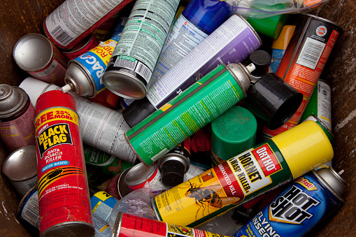 Fairfax, VA, USA - December 5, 2013: Bug spray cans gathered in order to be recycled. If there are still contents within the can, they will be properly processed by a household hazardous waste-processing facility. Empty aerosol cans are usually not classified as hazardous waste but rather because their contents are highly pressurized and capable of explosion if heated or otherwise mishandled.