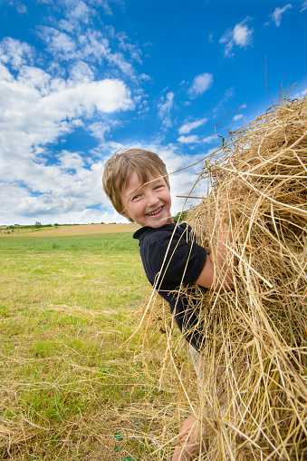 Kid playing with straw in a sunny summer day