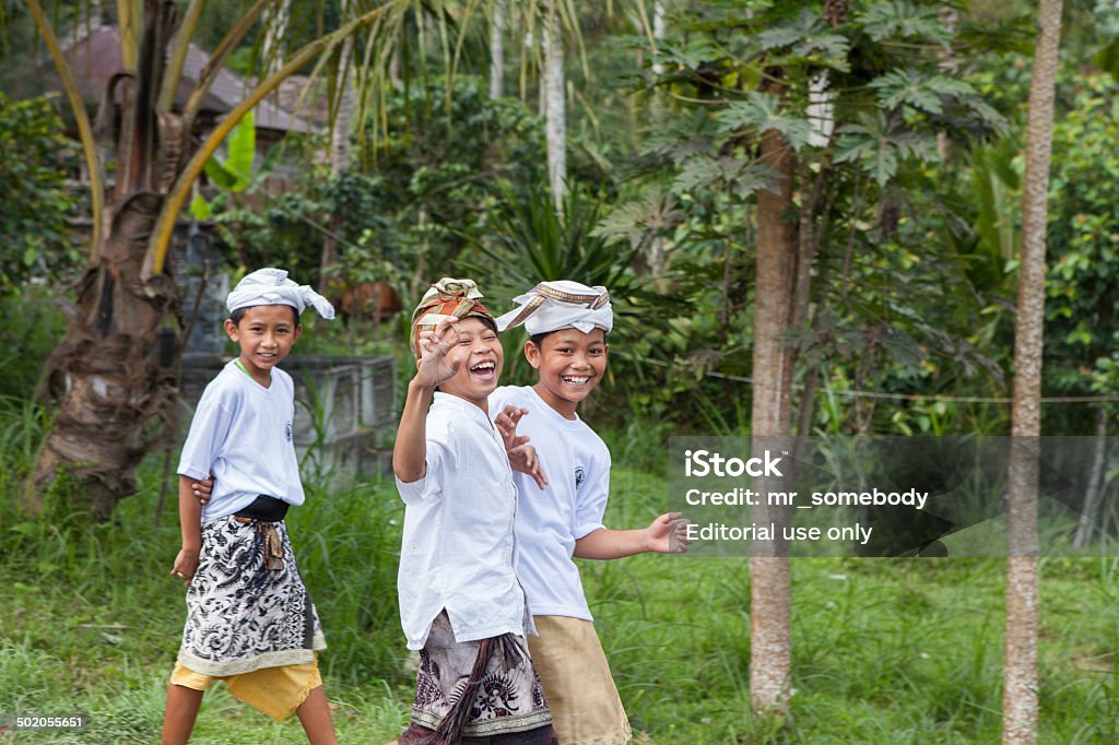 Children in the national dresses Bali, Indonesia - August 7, 2012: Children is walking on a street to a temple during a ceremony in the national dress. Bali Stock Photo