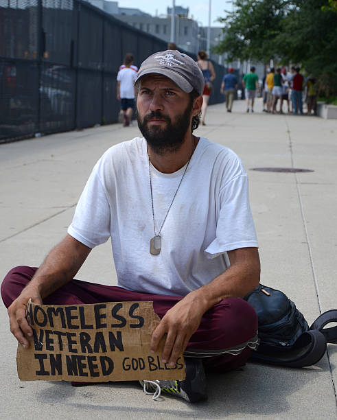 Homeless veteran pauses as he begs for money stock photo