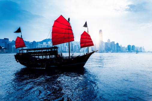 Traditional Chinese Junkboat sailing across Victoria Harbour at day,  Hong Kong