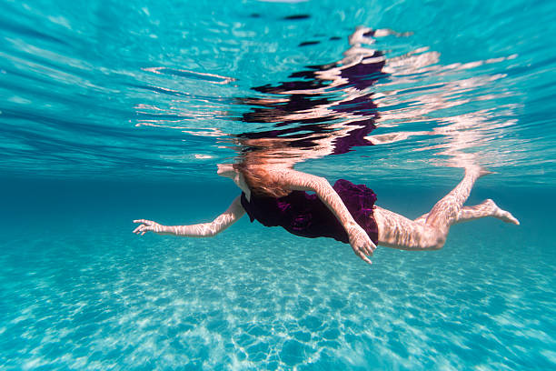 istock Purple dressed woman swimming 502058335