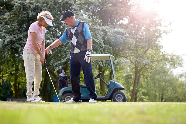 istock Golf pro teaching female golfer on putting green 502058895