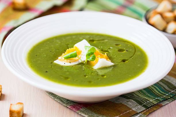 Green spring, summer healthy cream soup with herbs, egg, crouton stock photo