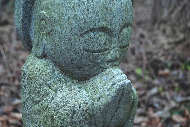 istock Buddha Statue in Green Stone Against Forest Floor 502063618