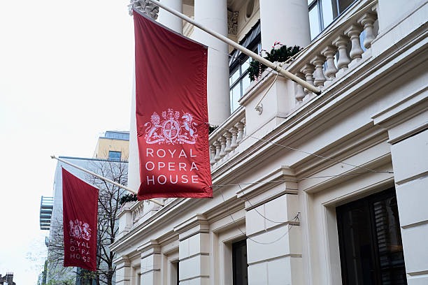 Royal Opera House London, UK - December 20, 2015: Large red banners in front of the Royal Opera House, depicting the Royal coat of arms. covent garden photos stock pictures, royalty-free photos & images