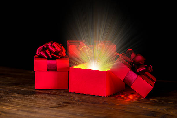 istock greeting opened box with bow and miracle light on wooden 502070224
