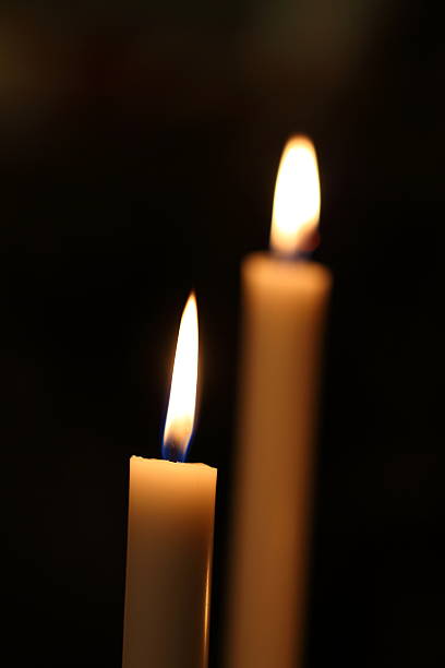 Candle light burning brightly in the black background, blank and wide background for copy space.