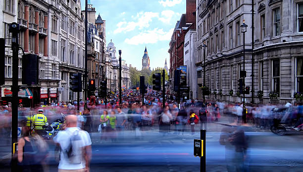 Daytime long exposure towards Whitehall Long exposure in the afternoon of a crowd of blurred people walking along Whitehall towards Trafalgar Square as a police man stands by a motorbike (left). houses of parliament london photos stock pictures, royalty-free photos & images